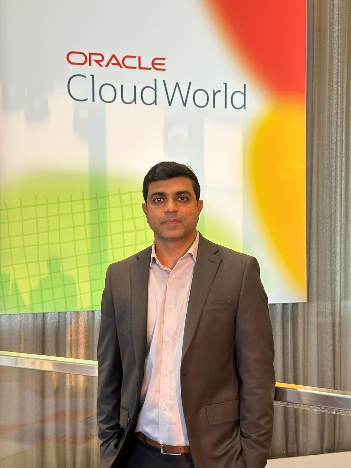 Baig Mohammed in front of the Oracle CloudWorld sign