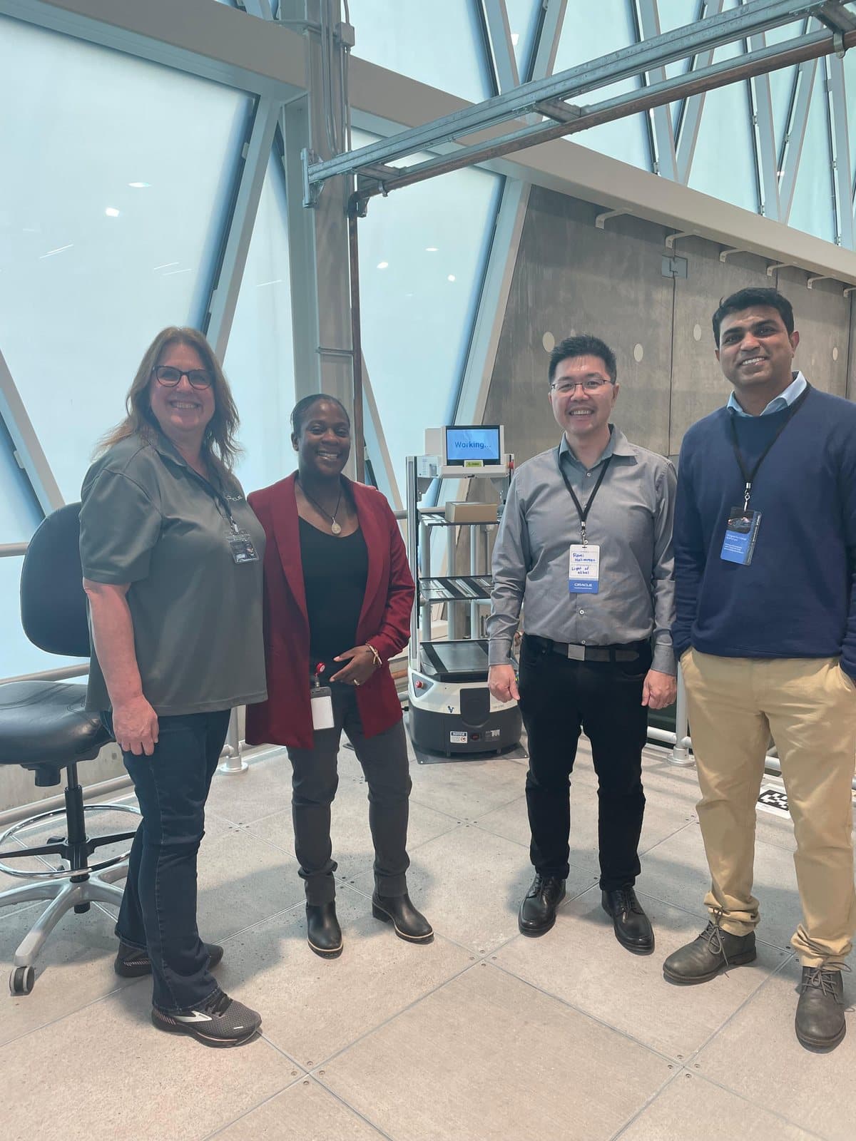 Baig Mohammed with Oracle colleagues beside an autonomous warehouse robot