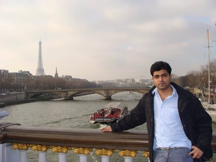 Baig Mohammed on a bridge over the Seine, with the Eiffel Tower in the distance